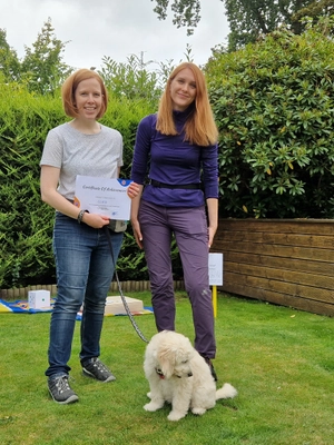 Katya with a happy client and their poodle after completing training